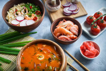 亚洲美食, 和拉面虾, 泰国菜在木碗, 鸡蛋面条, 准备, 辣椒, 洋葱和蘑菇, 辣, 假灰色背景, 特写镜头