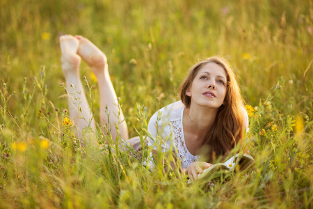 书的女孩躺在草地上做着梦