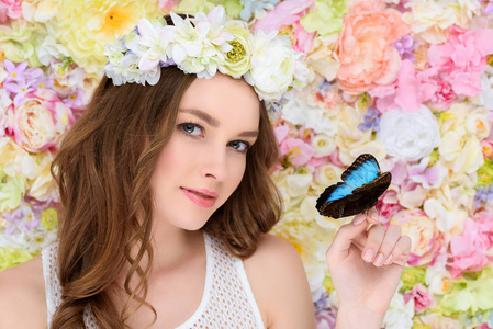 年轻妇女在花花圈与蝴蝶在手