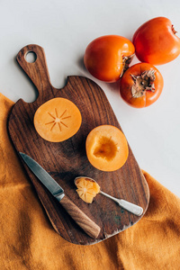 木板上柿子的刀和勺的顶部视图