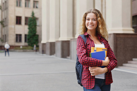 美丽的女学生站在大学校园前图片