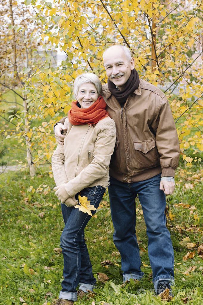 一个漂亮的老夫妇的肖像在自然愉快的夫妇在秋季森林