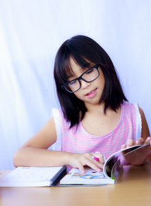 性格开朗的亚洲年轻女孩她做家庭作业的肖像
