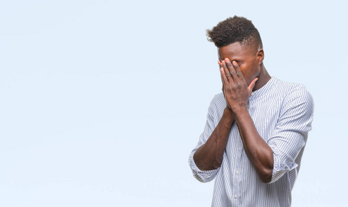 年轻的非洲裔美国人在孤立的背景下, 悲伤的表情覆盖脸与手, 而哭.