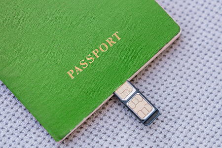 绿色护照与 sim 卡在灰色的纺织品背景