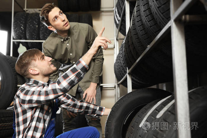 服务中心顾问帮助客户选择轮胎在商店