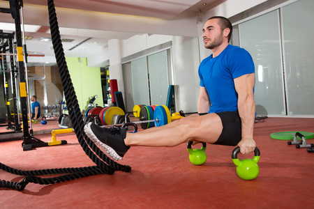 crossfit 健身男人我坐 kettlebells 我坐在行使