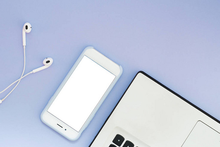 一个带白色屏幕的电话, 一台笔记本电脑和一个蓝色背景的耳机。平放置小工具和地方为文本