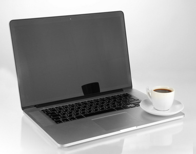 白色笔记本电脑与杯咖啡上白色隔离