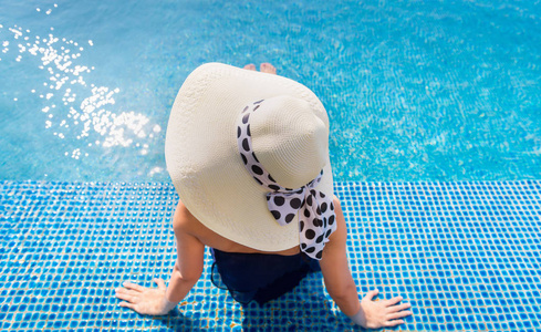 亚洲女子 Portait 在泳池中放松日光浴