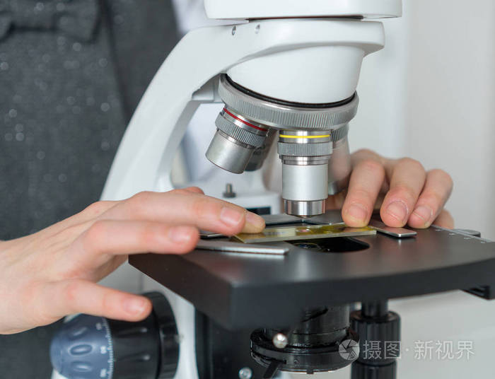 在使用显微镜的科学课的小女孩