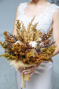 美丽的花朵和棉花在新娘手中的花束
