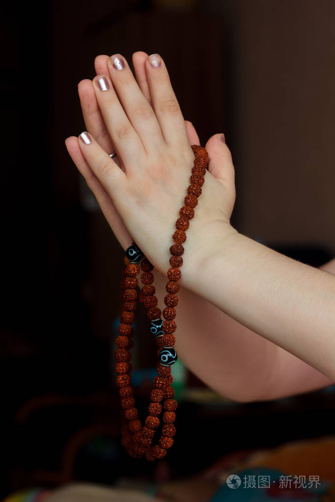 妇女手拿着 rudraksha 念珠与合十礼手印照片-正版商用图片07edok-摄