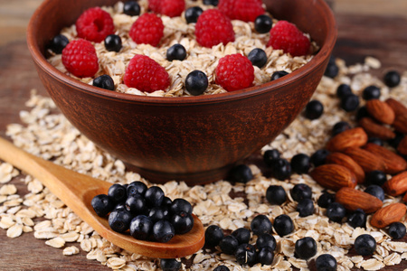 braun Schssel mit Haferflocken und Beeren auf einem Holztisch