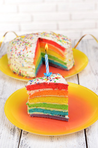 lckra rainbow cake p tallriken p bordet p ljus bakgrund