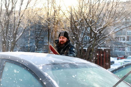 男子清洗在汽车玻璃的雪图片