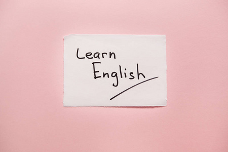 学习英语-在粉红色背景上的真实纸上的单词, 学习语言照片