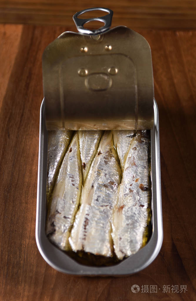 木制餐桌上的沙丁鱼罐头
