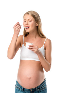 有吸引力的孕妇闭着眼睛吃酸奶查出的白色