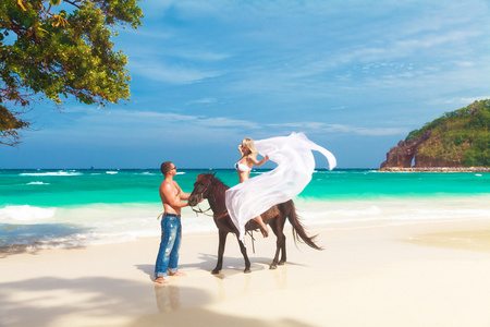 马到功成年轻夫妇在地处热带的海滩上行走马到功成的爱情照片