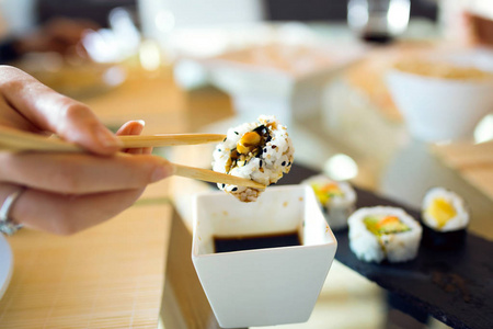 用筷子拿起寿司的女人的手
