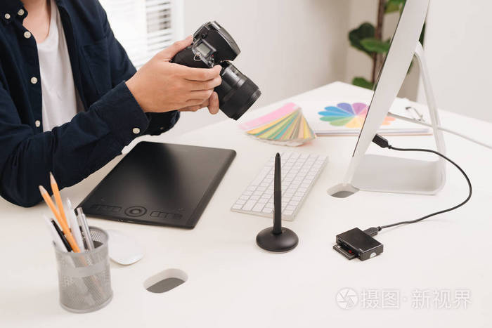 现代办公室的摄影师在办公桌前工作