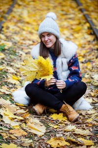 帽子和围巾户外在秋天的自然背景中微笑的年轻女子