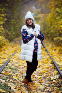 帽子和围巾户外在秋天的自然背景中微笑的年轻女子