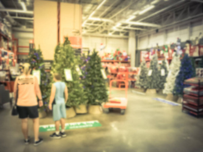 运动模糊客户购物与平板车为人造圣诞树多色灯在五金店。弥散经典, 装饰圣诞变色花环, 弦散景饰品