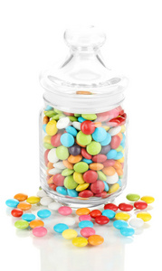 在白色上孤立的玻璃罐子里的多彩糖果