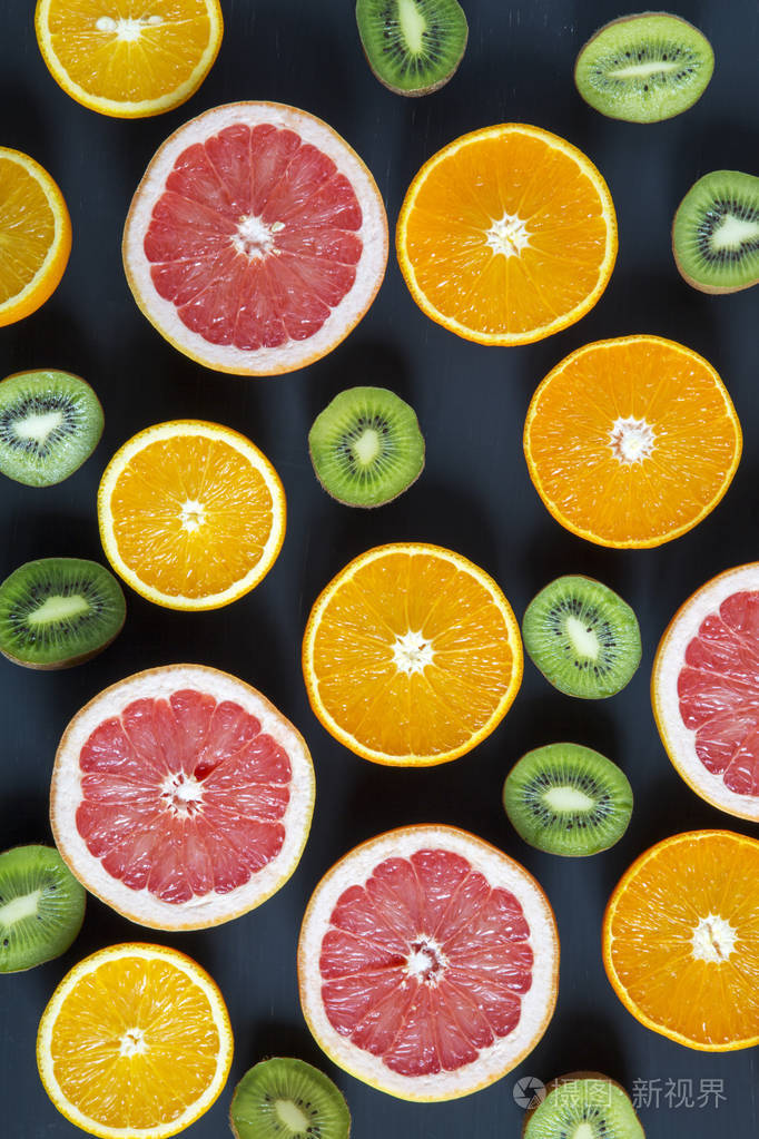木板带切片五颜六色的新鲜水果: 猕猴桃, 橙, 葡萄柚和普通话.