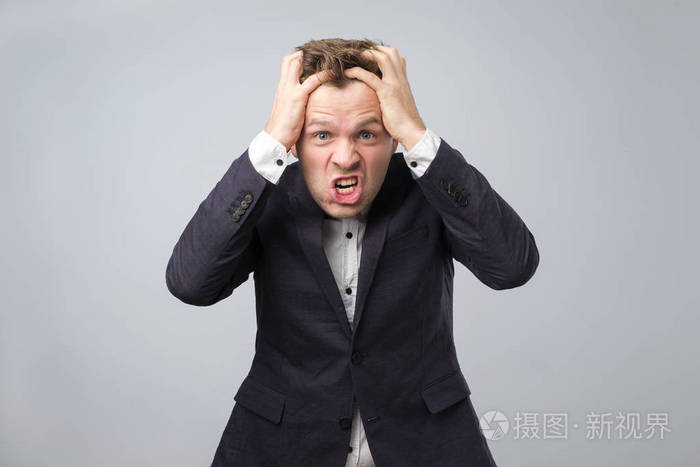 愤怒的欧洲商人在深蓝色西装疯狂的姿势