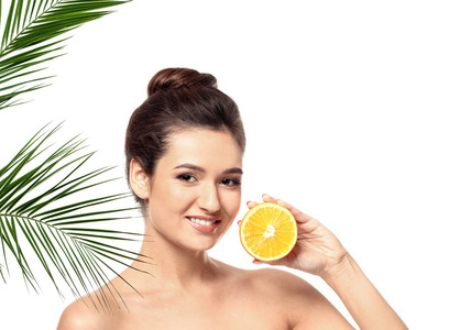 美丽的年轻妇女与柑橘类水果和棕榈叶的白色背景