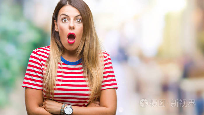 年轻美丽的女人休闲看在孤立的背景害怕和震惊的惊讶的表情, 恐惧和