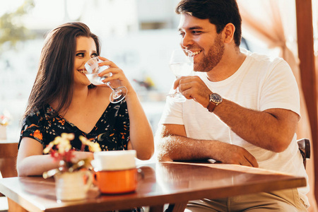 年轻情侣坐在咖啡馆里, 喝着水, 聊天, 享受着彼此共度的时光。