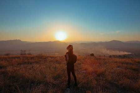 日落山。旅游自由快乐的女人伸出双臂机智