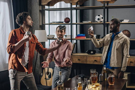 非洲裔美国人使用智能手机和看朋友杂耍啤酒罐