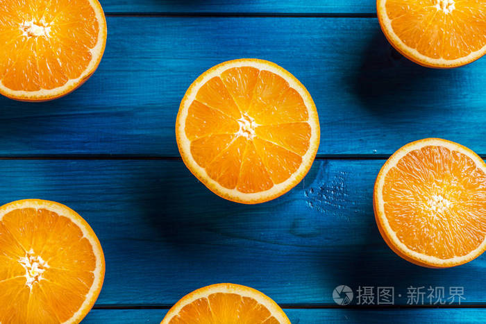 橙.在蓝色的桌子上切新鲜的桔子