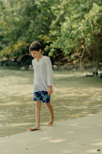 这个男孩正在海边玩岩石。