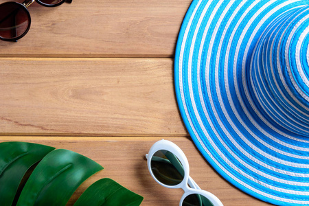 顶视图蓝色帽子和太阳镜上一张小木桌