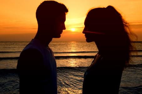 情侣在海滩上享受他们在日出的时间
