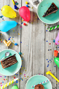 查看儿童生日表。框架的巧克力蛋糕, 松饼和装饰党在木质背景平躺