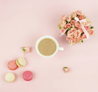 杏仁在柔和的颜色与花束粉红色玫瑰花和杯子可可粉在一个淡粉色背景。假期背景. 复制空间. 顶部视图