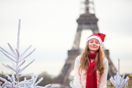 在圣诞老人的帽子，在埃菲尔铁塔附近的女孩