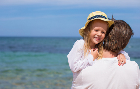 年轻的父亲和可爱的小女儿在海滩度假的乐趣
