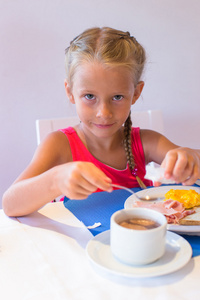可爱的小女孩，在度假村的餐厅吃早餐