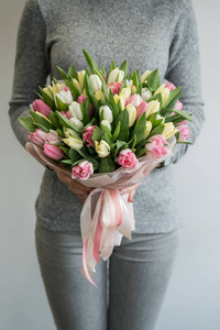 女性抱住美丽花束的彩色春季郁金香花