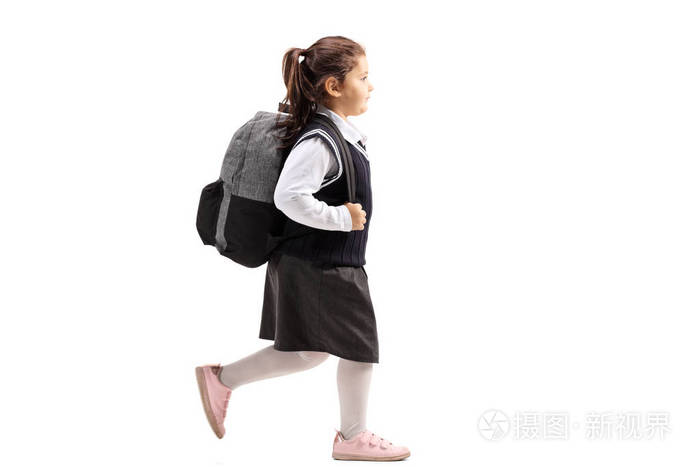 在白色背景的统一行走的一个女孩的完整长度剖面