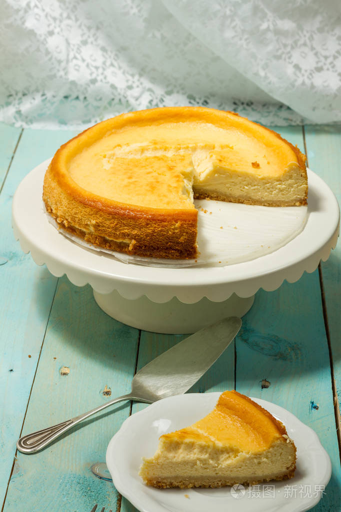 芝士蛋糕配烤黄油蓝色木桌白色板材