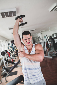 年轻有魅力的成年男子锻炼和做举重在健身馆。室内运动训练